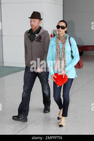 Esclusivo!! Boris Becker e Sharlely Kerssenberg, recentemente impegnati, arrivano all'aeroporto di Miami. Sharlely mostrò un cuore di pelliccia rossa con le parole 'Ich Leibe Dich'. Inoltre ha portato un anello grande del diamante anche se era sul dito medio della sua mano sinistra. Boris ha capovolto il ragazzo del bagaglio con una ventina di nota della libbra, Miami, FL, 3/2/09. Foto Stock