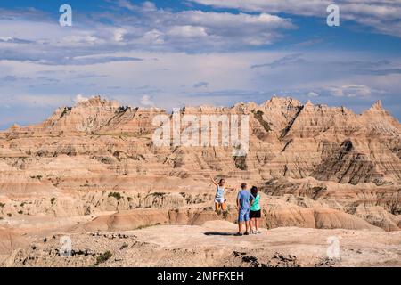 La famiglia fotografa la figlia che salta al White River Valley nel Badlands National Park, South Dakota. Foto Stock