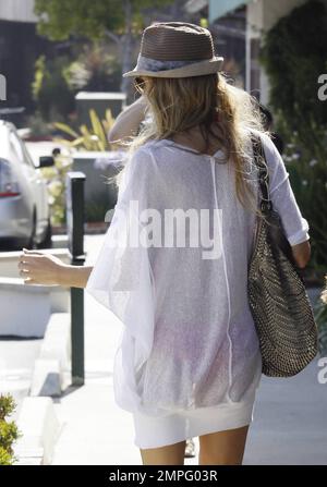 L'ex e la star di Eddie Cibrian Brandi Glanville, 'Real Housewives of Beverly Hills', mostra le sue lunghe e sottili gambe in un bikini rosa e vestito bianco mentre trascorre la sua vacanza del quarto luglio al Malibu Country Mart e Tony Taverna's. Malibu, California. 7/4/11. . Foto Stock