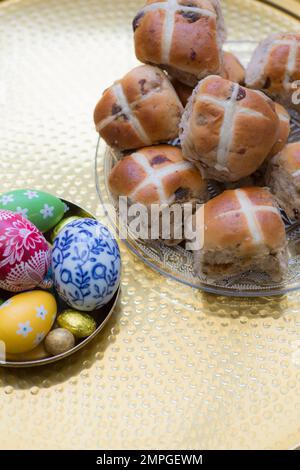 Tavolo di Pasqua con focaccine a croce calde e uova decorate Foto Stock