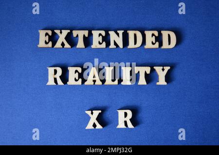 Extended Reality XR, parole in lettere alfabetiche di legno isolate su sfondo blu Foto Stock