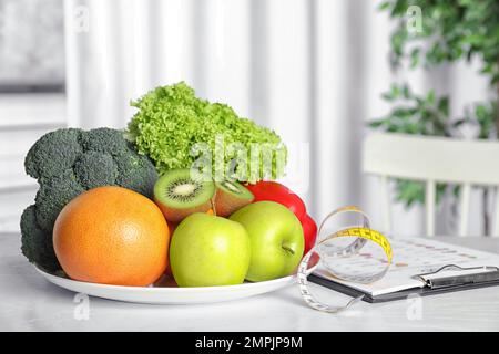 Metro nastro, verdura e frutta sulla tavola. Programma di dieta da nutrizionista Foto Stock