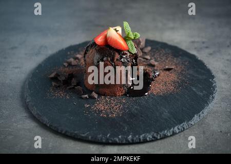 Deliziosa torta di lava al cioccolato caldo sul tavolo grigio Foto Stock