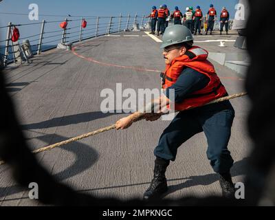 221102-N-UL352-1132 GOLFO ARABICO (2 novembre 2022) Specialista culinario 3rd Classe Brandon del Rio, assegnato al cacciatorpediniere missilistico guidato USS Delbert D. Black (DDG 119), lancia una linea durante un rifornimento in mare con nave secca da carico e munizioni USNS Alan Shepard (T-AKE 3) nel Golfo Arabico, 2 novembre. Delbert D. Black viene impiegato nell'area operativa della flotta statunitense 5th per garantire la sicurezza e la stabilità marittima nella regione del Medio Oriente. Foto Stock