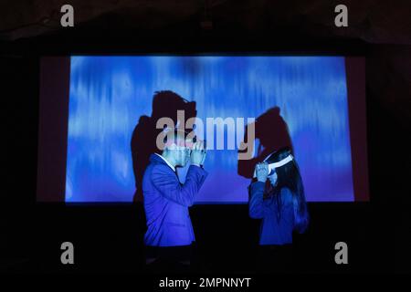 Imprenditori maschili e femminili che indossano occhiali futuristici nel centro congressi illuminato Foto Stock