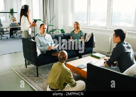 Professionisti in affari che discutono l'uno con l'altro in ufficio Foto Stock