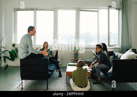 Professionisti di affari multirazziali che discutono con a vicenda in riunione all'ufficio Foto Stock