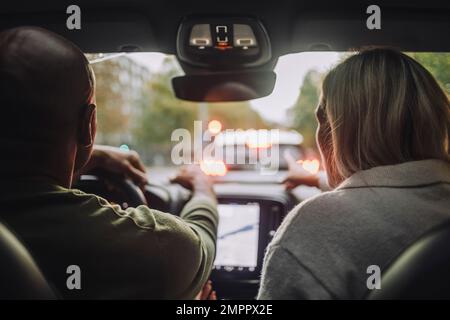 Vista posteriore di una coppia che attraversa l'auto Foto Stock
