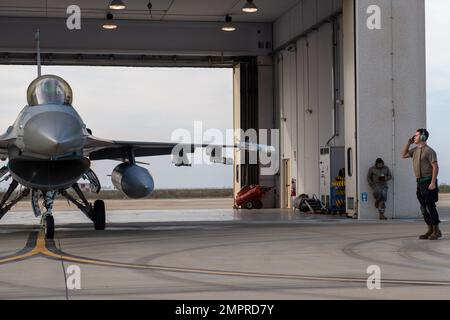 Airman 1st Class Logan Turner, 555th Fighter Generation Squadron capo equipaggio, saluta un 555th Fighter Squadron F-16 Fighting Falcon pilota durante l'esercizio Falcon Strike 2022 presso Amendola Air base, Italia, 15 novembre 2022. Falcon Strike 22 ha dimostrato la capacità delle nazioni della NATO di condurre operazioni aeree multinazionali offensive e difensive che integravano la quarta e la quinta generazione di airpower. Foto Stock