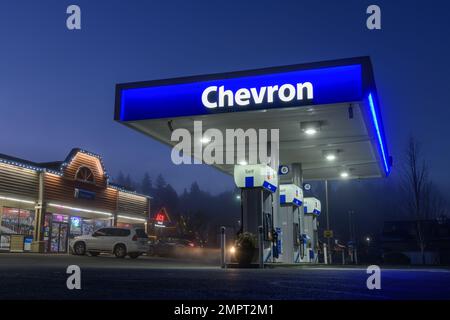 Duvall, WA, USA - 29 gennaio 2023; tenda blu illuminata con testo della compagnia di benzina Chevron di notte Foto Stock