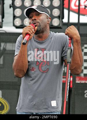 Cantante principale di Hoootie & The Blowfish e vincitore del CMA New Artist of the Year, Darius Rucker suona dal vivo sotto la pioggia prima della NASCAR Coke Zero 400 al Daytona International Speedway. Nonostante la pioggia, il cantante rock-gired-country sembrava felice mentre si muoveva intorno al palco cantando e suonando la sua chitarra. Daytona Beach, Florida. 07/03/10. Foto Stock