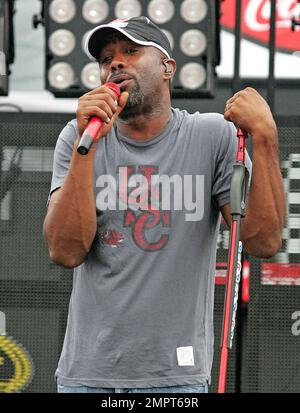 Cantante principale di Hoootie & The Blowfish e vincitore del CMA New Artist of the Year, Darius Rucker suona dal vivo sotto la pioggia prima della NASCAR Coke Zero 400 al Daytona International Speedway. Nonostante la pioggia, il cantante rock-gired-country sembrava felice mentre si muoveva intorno al palco cantando e suonando la sua chitarra. Daytona Beach, Florida. 07/03/10. . Foto Stock