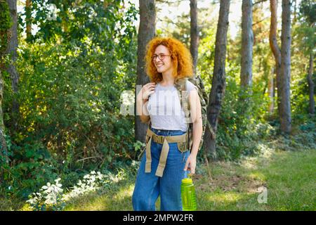 Una donna backpacking in natura in una giornata di sole Foto Stock