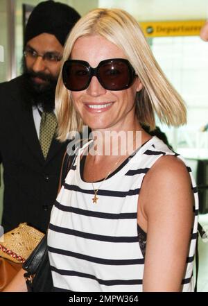 La personalità della TV britannica Denise van Outen mostra la sua nuova abbronzatura mentre arriva all'aeroporto di Heathrow da Dubai dopo aver goduto una vacanza lì. Indossando un top a righe e una zip con leggings dettagliati e comodi stivali Ugg, Denise dall'aspetto rilassato passava per l'aeroporto e si aiutava a spingere i bagagli. Denise indossava anche una collana con fascino stellato e mostrava le sue unghie rosse lucide. Londra, Regno Unito. 03/27/11. Foto Stock