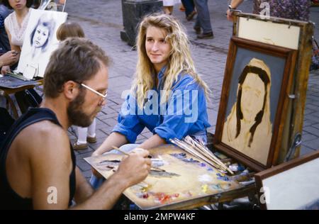 Storico, Archivio immagine di Un artista di strada con Easel e pitture Pittura il ritratto di Una giovane femmina in olio per le strade di Mosca, Russia, 1990 Foto Stock