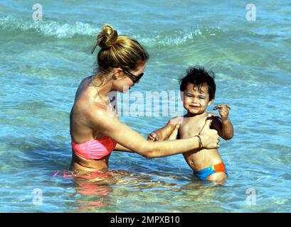 Supermodel Doutzen Kroes mostra della sua figura stupefacente in un bikini rosa come lei spende un certo tempo di qualità sulla spiaggia con il figlio di 17 mesi Phyllon Joy Gorre. I due nuotarono e giocarono nella sabbia. Miami Beach, Florida. 18th giugno 2012. . Foto Stock