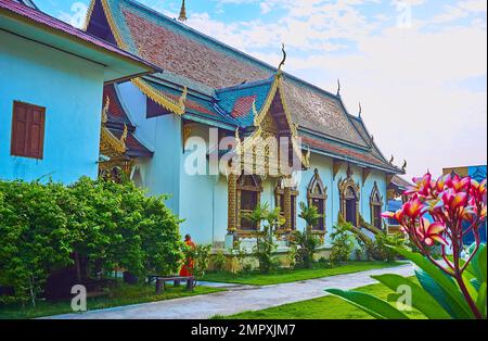 Parete laterale ornata della viharn del tempio di Wat Chiang Man, circondata da letti da giardino, Chiang mai, Thailandia Foto Stock