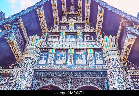 L'estremità timpano in legno di teak del Viharn di Wat Lok moli, decorata con ornamenti in stucco a rilievo e vetro colorato, Chiang mai, Thailandia Foto Stock