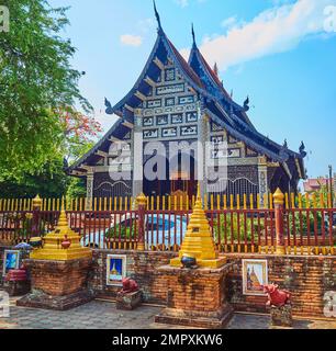 Piccoli santuari dorati (paletti planetari) di fronte al viharn medievale di legno di teak di Wat Lok moli, Chiang mai, Thailandia Foto Stock