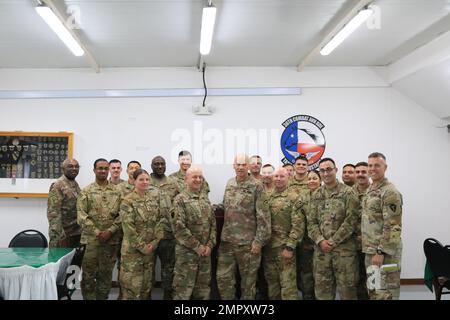 STATI UNITI Thomas Spencer, comandante generale della Divisione fanteria 42nd, New York Army National Guard (al centro, quarto da destra), si pone per una foto di gruppo con i soldati e gli alti dirigenti del 3rd Battaglione, 142nd Aviation Regiment, Battaglione elicottero Assault, attaccato alla Brigata Aviazione di combattimento 36th, a Camp Buehring, Kuwait, 23 novembre 2022. Il CAB 36th, mobilitato come Task Force Mustang, fornisce operazioni aeronautiche dell'esercito a tutto spettro per la Combined Joint Task Force – operazione Incented Resolve mission per consigliare, assistere e consentire alle forze partner di sconfiggere in modo duraturo l'ISIS Foto Stock