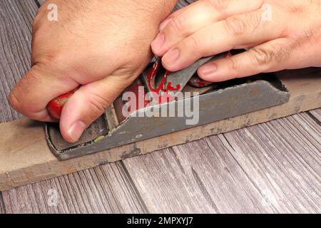 primo piano delle mani di un utensile da lavoro uomo piallato carpenteria sul banco di lavoro Foto Stock