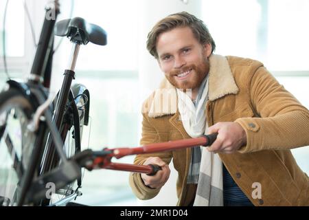 Ladro a rubare una moto parcheggiata in una strada di città Foto Stock