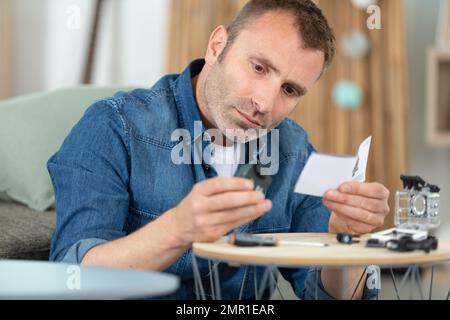 L'uomo installazione di sorveglianza telecamere TVCC a casa Foto Stock