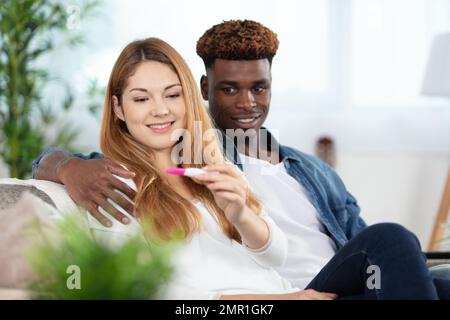 coppia che celebra il risultato positivo della prova di gravidanza domestica Foto Stock