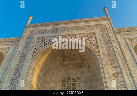 Un inquadramento ad angolo basso delle belle pareti d'ingresso arcuate del Taj Mahal ad Agra, India Foto Stock