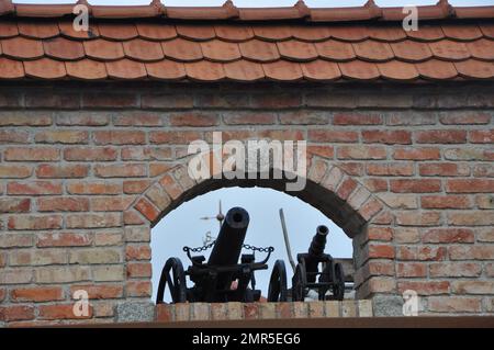 Villa in stile tedesco a Obernberg am Inn, Germania Dicembre 2022.Miniature repliche di cannoni come decorazione sulla finestra del muro di mattoni. Foto Stock