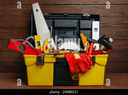 Scatola con diversi utensili da falegname su tavola in legno Foto Stock