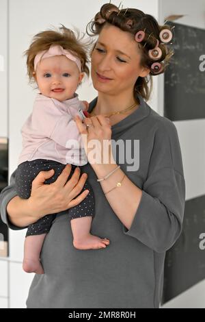 Madre con i ricci nei suoi capelli, coccolando con figlia, bambino, bambino, ragazza, 5 mesi, Baden-Württemberg, Germania, Europa Foto Stock