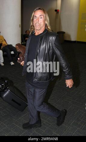 Esclusivo!! La rock star Iggy Pop arriva all'aeroporto di Miami con la sua ragazza Nina Alu. Pop sembrava avere difficoltà a camminare come aveva un grave limp. Miami, Florida 4/2/09. . . Foto Stock