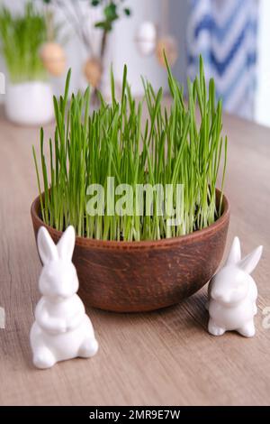 Casa easter decor. Avena verde, conigli decorativi e uova Foto Stock