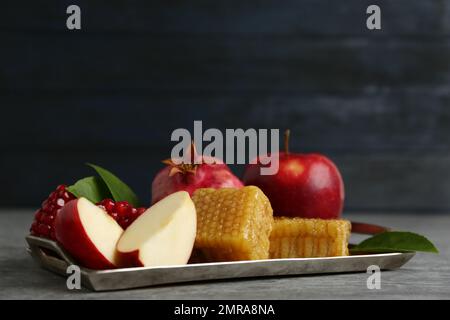 Favi, mele e melograno su tavola grigia. Rosh Hashanah vacanza Foto Stock