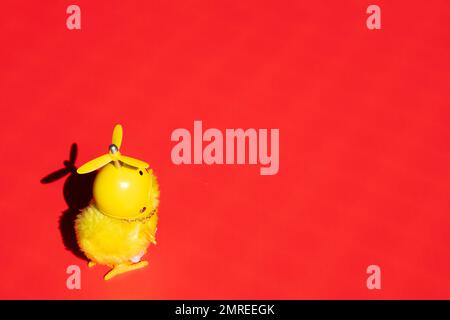 Il pulcino piccolo carino in un casco è solo su uno sfondo rosso. Concettuale. Foto Stock