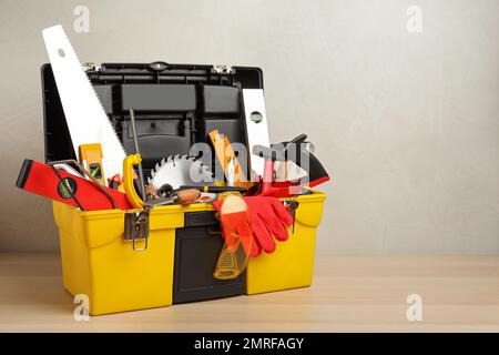 Scatola con diversi utensili da falegname su tavola in legno. Spazio per il testo Foto Stock