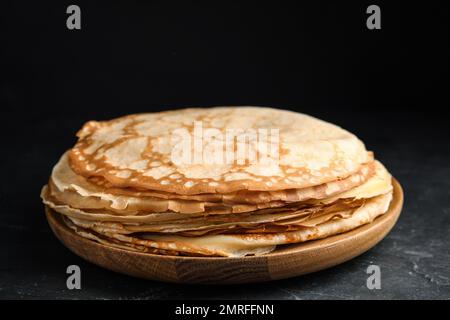 Pila di frittelle fresche sottili sul tavolo nero Foto Stock