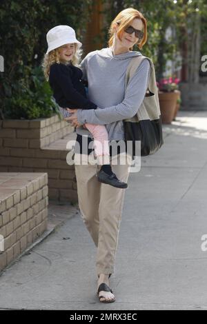 L'attrice marcia Cross va per una passeggiata informale con la figlia che prende il bel sole della domenica. Croce vestita in un elegante pullover a righe felpa con cappuccio, arrotolato khakis e lei e sua figlia indossavano cappelli corrispondenti. Dopo aver preso un caffè con le sue sneakers, Cross in seguito cambiò con i suoi sandali e portò una semplice borsa tote CŽline in pelle e tessuto di design. Cross è la madre di due graziose figlie gemelle Eden e Savannah. Los Angeles, California. 03/13/11. Foto Stock