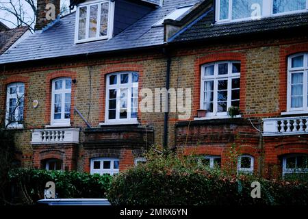 Un edificio in mattoni a due piani con cespugli di fronte Foto Stock
