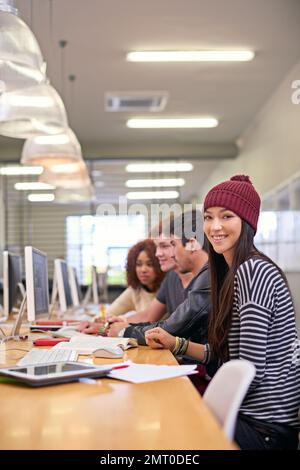 L'investimento nella conoscenza paga l'interesse migliore. studenti che lavorano su computer in una biblioteca universitaria. Foto Stock