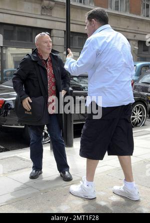 Il musicista scozzese Midge Ure si pone per la telecamera prima di dare al suo amico, radio host Dale Winton, un abbraccio dopo aver lasciato gli studi della BBC radio 1. Londra, Regno Unito. 07/08/10. Foto Stock