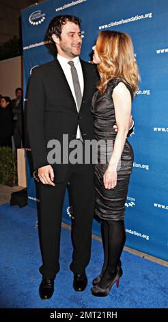 In uno snellente abito da cocktail nero Chelsea Clinton travi come lei tiene le mani con il marito Marc Mezvinsky sul tappeto blu durante Millennium Network Event ospitato dall'ex presidente degli Stati Uniti Bill Clinton tenuto al Boulevard 3. Los Angeles, California. 03/17/11. Foto Stock