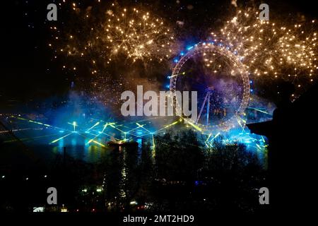 I festeggiamenti di Capodanno al Whitehall Court sul tetto illuminano lo skyline di Londra, riflettendo il London Eye e lo skyline del Tamigi con fuochi d'artificio. Londra, Regno Unito. Foto Stock