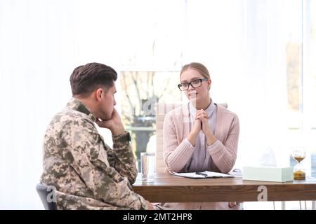 Psicoterapeuta che lavora con ufficiale militare in carica Foto Stock