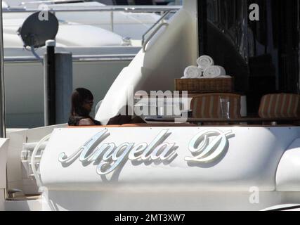 ESCLUSIVO!! Naomi Campbell e il suo fidanzato russo Vladislav Doronin vivono la vita di lusso navigando l'acqua intorno a Miami su uno yacht. La coppia ha passato l'enorme villa che ha acquistato su Star Island mentre lasciavano la Marina. Il Supermodel si è rilassato in una sedia sulla parte superiore della double decker Angela D prendere il sole e chiacchierare sul suo cellulare. Miami, Florida. 10/11/09. Foto Stock