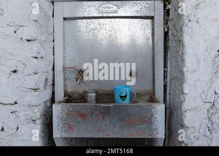 Assuan, Egitto. Dicembre 9th 2022 acqua di Cean fontana potabile con mug faccia sorridente di plastica, lungo il fiume Nilo nell'Egitto superiore vicino alla città di Assuan, Foto Stock