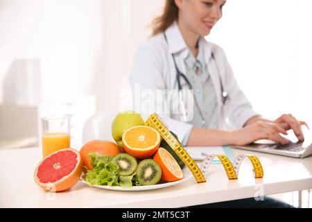 Prodotti sani, metro a nastro e nutrizionista sfocato sullo sfondo Foto Stock