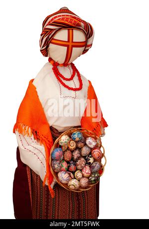 Bambola Ucraina-amuleto Lyalka Motanka isolato su sfondo bianco. Uova di Pasqua Pysanka nel cestino. Dipinto uovo. Ucraina abiti tradizionali donna. Foto Stock