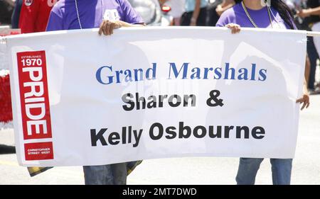 I Grand Marshals Sharon e Kelly Osbourne navigano lungo il Santa Monica Boulevard su un galleggiante dai colori brillanti con arcobaleno ornato da paillettes e abiti coordinati durante la sfilata annuale di Los Angeles Gay Pride 40th. Secondo i rapporti le stelle della TV di realtà sono state confrontate dai manifestanti anti anti-gay, ma il duo madre-figlia è stato inalterato e continuato sopra. Kelly, che ha anche mostrato la sua scissione e goduto di un lollipop, in seguito firmato autografi e Sharon abbracciato un fan. Si stima che 400, 000 persone siano state presenti all'evento ad alta energia. Los Angeles, California. 06/13/10. . Foto Stock